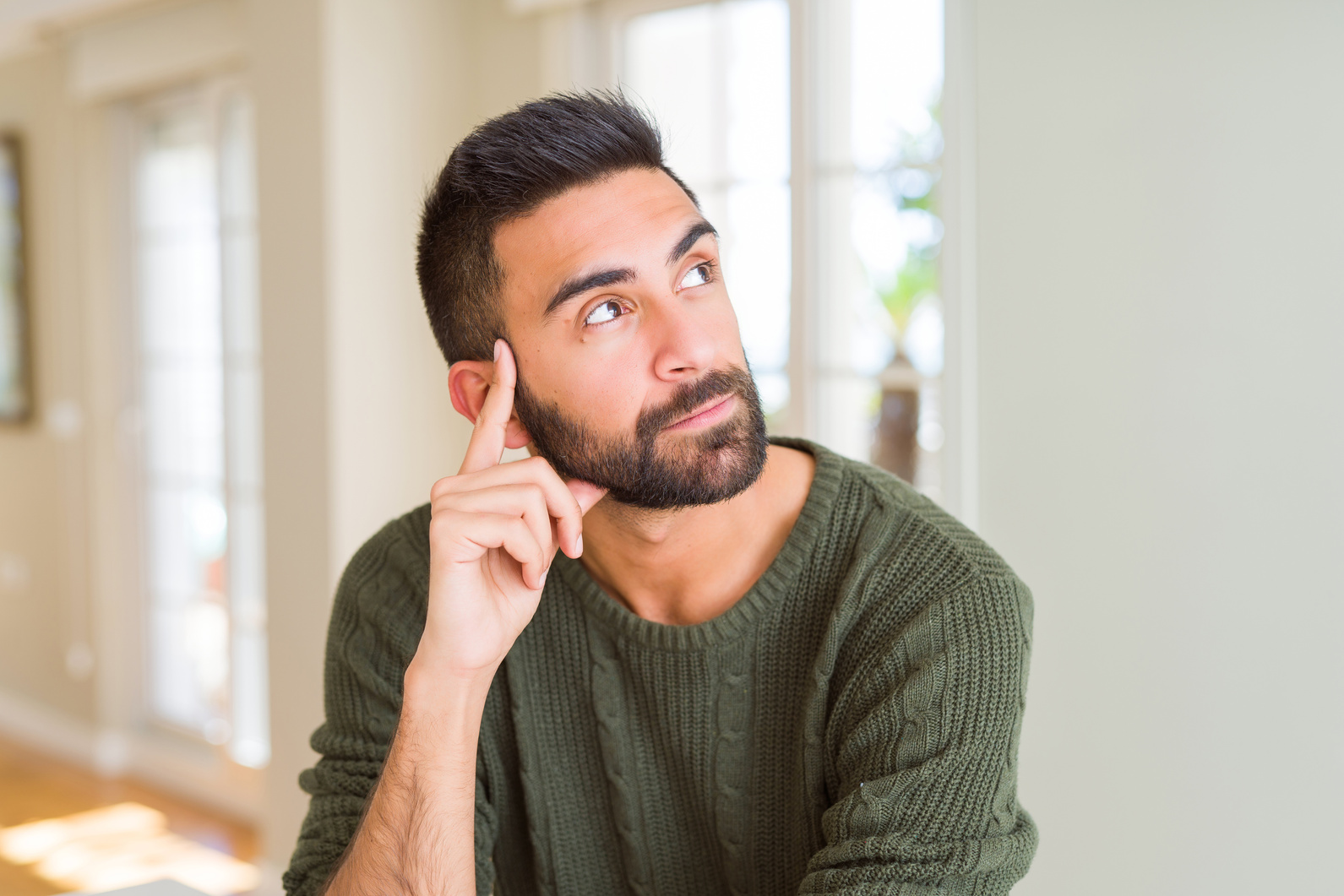 Handsome man thinking confused about doubt, questioning an idea